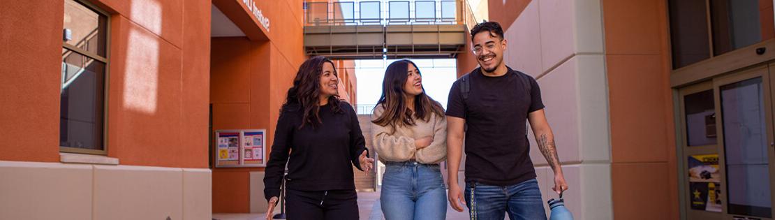 3 students walk and talk in a breezeway at Northwest Campus